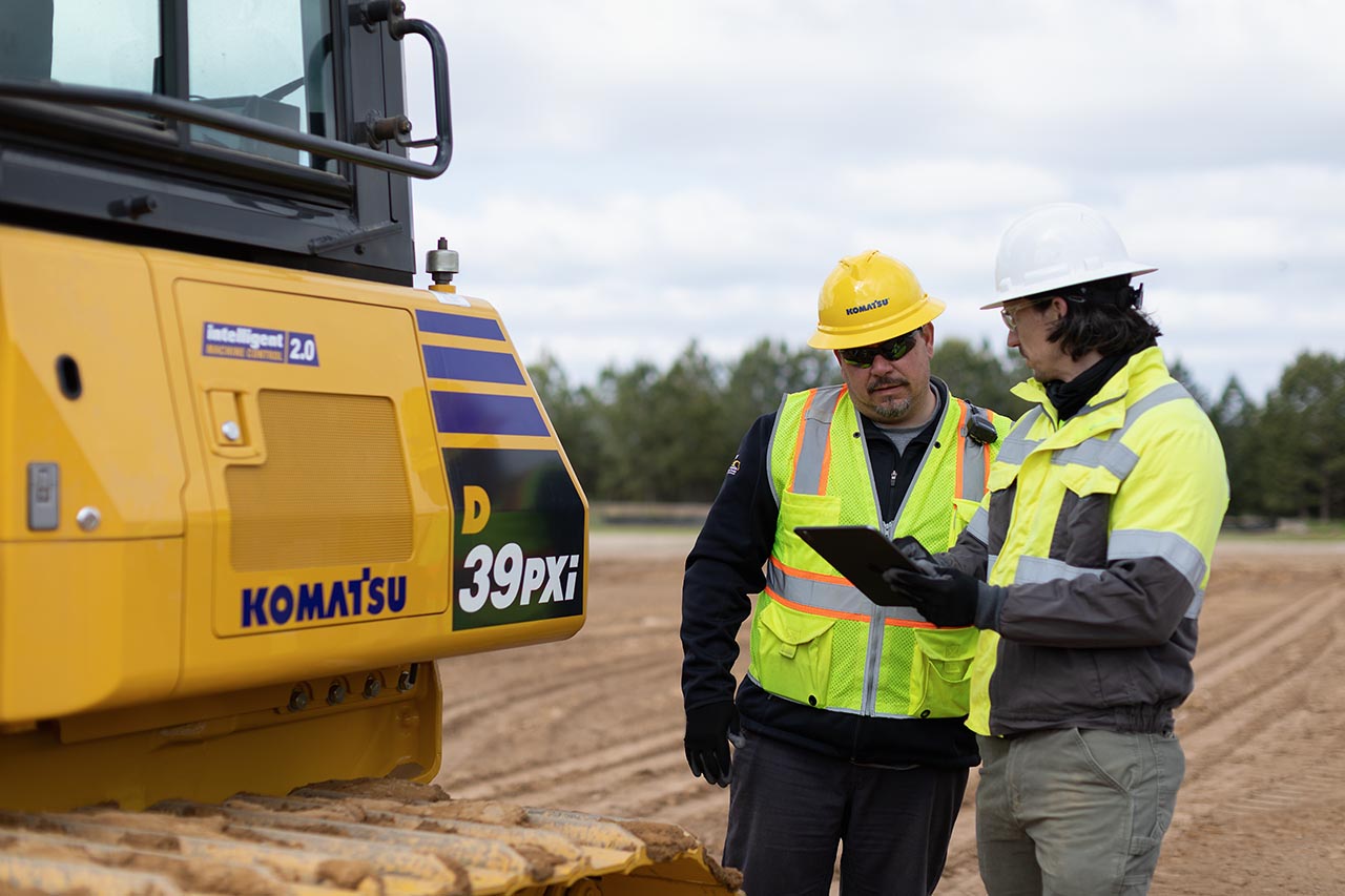 Two technicians next to Komatsu D39PXi dozer
